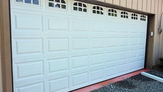 Wide garage door with arched windows on a pole-barn style building